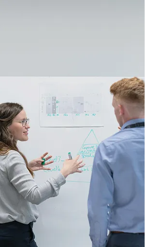 外国人の男性と女性がホワイトボードの前で話している